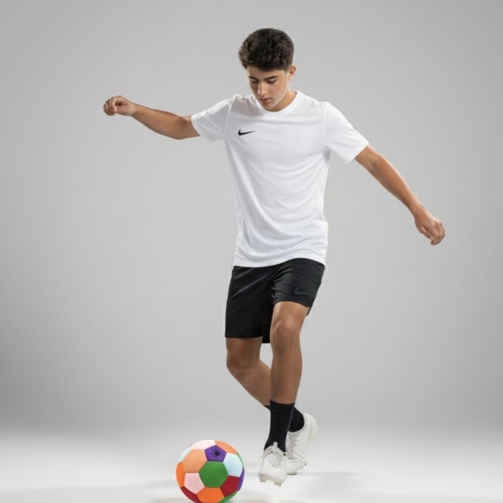 Person in white sports jersey and black shorts with a colorful soccer ball on a gray background