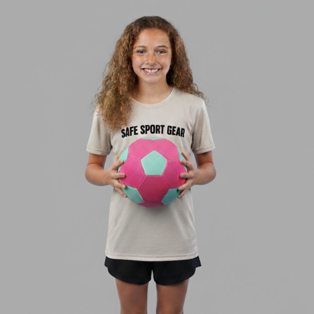 Girl wearing a 'Safe Sport Gear' t-shirt holding a pink and green ball on a gray background