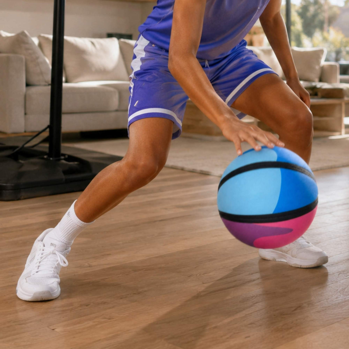 Person in blue athletic outfit with a colorful HouseHoops basketball - SH indoors.