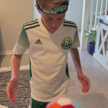 Young boy playing with The House Ball - soccer ball made for home, inside his home. 